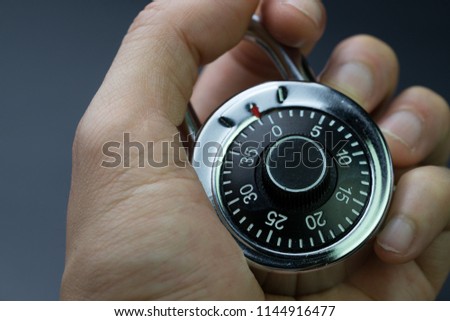 Security, safety or cyber encryption concept, man hand holding combination circle lock pad with passcode number access to unlock it.