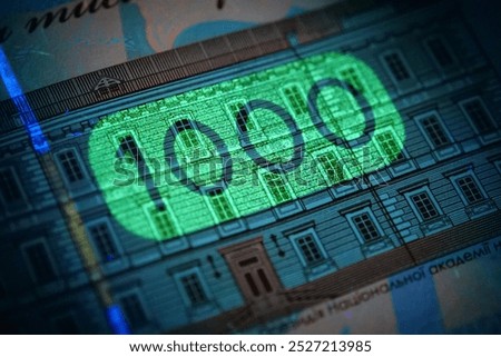 Security signs and elements under UV light on banknote 1000 Hryvnia of Ukraine. Ukrainian banknote of maximum denomination under ultraviolet light