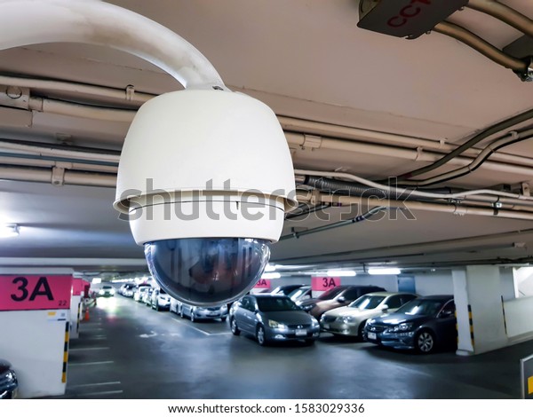 Security surveillance camera inside car park\
building walk way. Record situation around area standard safety\
technology system in smart modern building. Help to prevent crime.\
parking lot security.