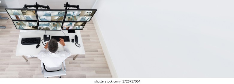 Security System Operator Looking At CCTV Camera Footage On Computer
