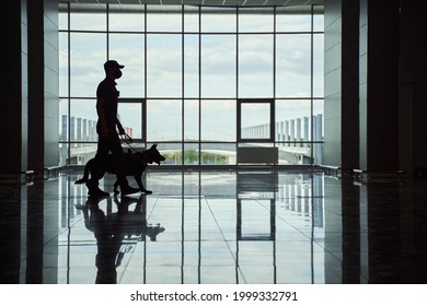 Security Worker And Police Dog Walking Down Airport Terminal