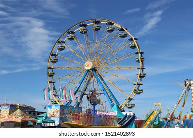 Sedalia, Missouri / USA - August 12 2019: Ferris Wheel at Missouri State Fair beneath Mostly Clear Sky in Summer Time