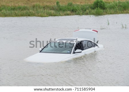 Sedan car swamped by flood water in East Houston, Texas, US by Harvey Tropical Storm. Submerged car on deep heavy high water road. Disaster Motor Vehicle Insurance Claim Themed. Severe weather concept