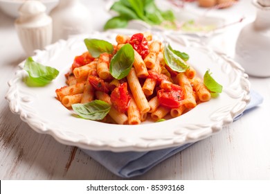 Sedani Rigati avec tomates cerises et basilic. Cuisine italienne. Cuisine italienne. De la nourriture maison. Concept pour un repas savoureux et sain. Arrière-plan blanc bois. 