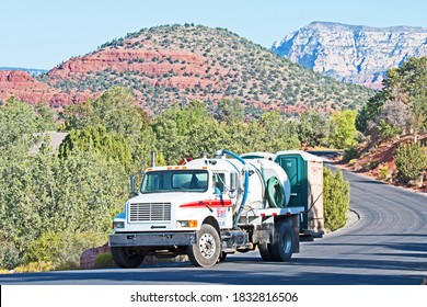 Sedona, Arizona/USA - October 13 2020: A Septic Tank Truck Carrying Two Portable Toilets On Its Back Is Silhouetted Against Sedona's Famous Red Rocks.