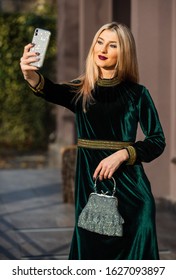 Seducing You. Glamour Velvet Textile. Sexy Businesswoman Make Selfie On Phone. Modern Life. Girl Care Gem Stone Handbag. Glam Clutch Accessory. Fashion Blog. Elegant Woman In Green Velour Dress.