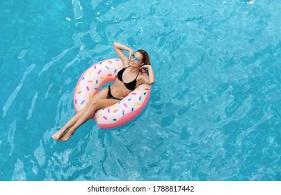 Seductive Caucasian Girl In Bikini Swimming On Inflatable Ring In Pool, Overhead View. Empty Space