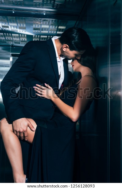 エレベーターでキスとハグをする誘惑的な夫婦 の写真素材 今すぐ編集