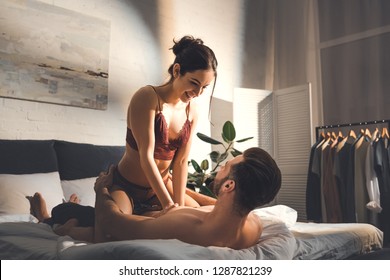 Seductive Young Couple On Bed During Foreplay