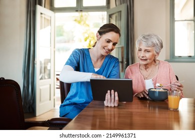 See how easy it is to use. Shot of a young nurse and senior woman using a digital tablet at breakfast time in a nursing home. - Powered by Shutterstock