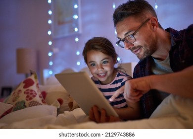 See, they lived happily ever after. Shot of a little girl and her father using a tablet before bedtime. - Powered by Shutterstock