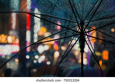 The See Through Umbrella With City Light Bokeh Background In Raining Day Concept.