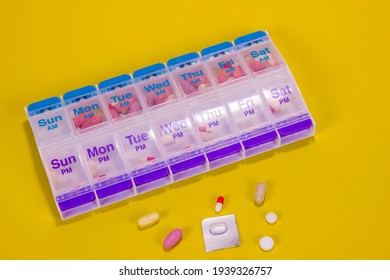 See Through Weekly Pill Box On Smooth Yellow Background