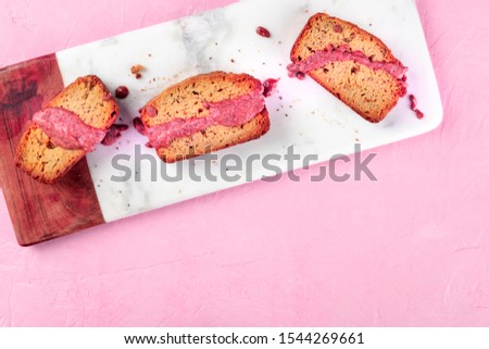 A seed cake with ruby chocolate, shot from above on a pink background with copyspace