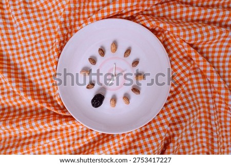 Seed clock composition on twisted orange gingham cloth background