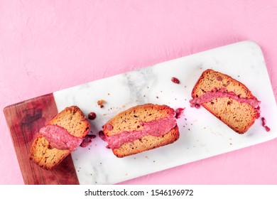 A seedcake with ruby chocolate, shot from the top on a pink background with a place for text