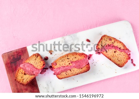 A seedcake with ruby chocolate, shot from the top on a pink background with a place for text