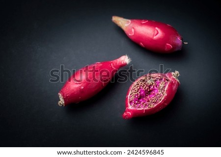 Seedpod of Gymnocalycium cactus isolated on black background. Ripe red cactus fruits has cracked and visible seeds inside. Empty blank copy text space.