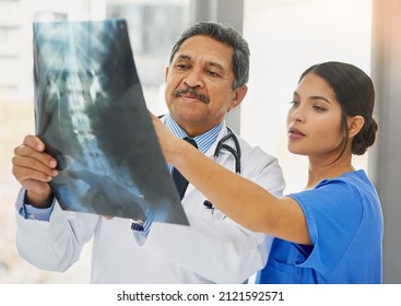Seeing right through to the problem. Shot of a mature doctor and young nurse looking at an x ray together.