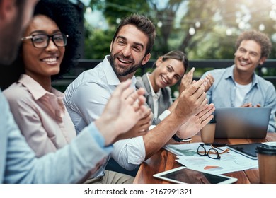 Seeing their success all come together. Shot of a group of colleagues applauding during a meeting at a cafe. - Powered by Shutterstock