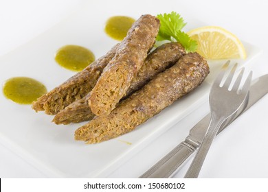 Seekh Kebabs -  Minced meat kebabs served with mint and coriander sauce and lemon wedges.