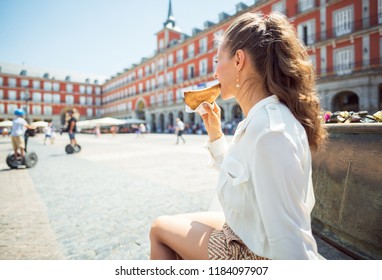 Seen From Behind Young Woman At Plaza Mayor Eating Empanada