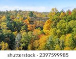 Seen from Lookout Point atop Battleship Rock, surrounded by colorful autumn leaves, a large rock arch is the geologic centerpiece of Natural Bridge State Park in the Red River Gorge area of Kentucky.