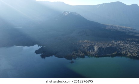 At Segara Anak Lake on Mount Rinjani, a group of young campers enjoys the cool, crisp air by the serene blue waters. Their tents line the lakeshore, creating a peaceful moment in nature’s breathtaking - Powered by Shutterstock