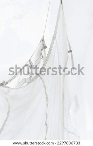 Segment of folded white parachute fabric closeup. Monochrome background with copy space for your design.