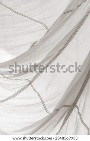 Segment of folded white parachute fabric closeup. Monochrome background with copy space for your design.