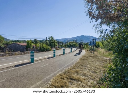 Segregated cycle lane running parallel to a local road. Group of cyclists circulating