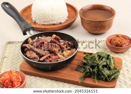 Se'i Sapi or  Beef Sei is Indonesia Traditional Smoked Beef, Served with Boiled Cassava Leaves and Sambal Luat or Sambal Matah. Typically Food from Nusa Tenggara, Indonesia