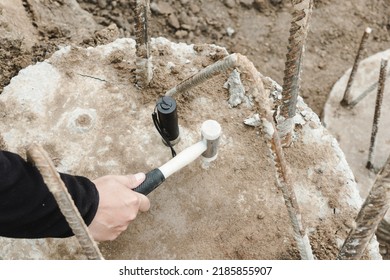 Seismic test on concrete pile. Engineer using the PIT Hand-Held Hammer, the PIT Accelerometer and the Pile Integrity Tester to detect Neck Bulge and Void in the piles