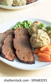 Seitan Steak With Bread Dumplings And Fresh Peas And Baby Carrots