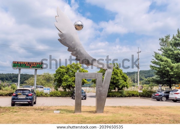 Sejeong South Korea; August 16, 2021: Stainless\
steel sculpture called Life Flies by Kim Seon Woo near parking lot\
in public park.