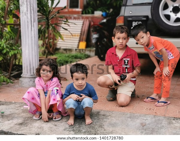 Selangor, Malaysia :016/05 /2019 : Image of\
Children ficussing on playing remote control car at the house\
compound near Semenyih, Selangor,\
Malaysia.