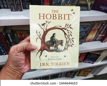 Selangor, Malaysia - 5 July 2019 : Hand Hold A J. R. R TOLKIEN Book Title - THE HOBBIT For Sale At Library Book Stores With Selective Focus.