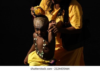 Selangor, Malaysia - 6 February 2017 : A child helped by his mother to carry a pot of milk on top of his head, ahead of Thaipusam procession in Batu Cave