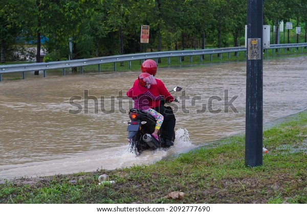 Selangor, Malaysia -\
December 18, 2021 - A motorcycle riding through flooding in Klang\
road after heavy\
rain.