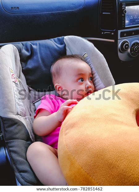 Selangor, Malaysia -\
December 2017 : A 6 month old baby is playing in her car seat while\
the car is not\
moving.