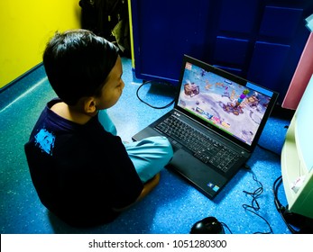 Selangor, Malaysia - February 7, 2018: 9 Year Old Asian Boy Is Watching The YouTube Channel Through The Laptop While Sitting On The Floor.