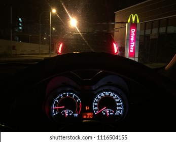 Selangor, Malaysia - JUNE 20th, 2018: Driving In A Car As A Customer, Order And Buy Fast Food From McDonalds Drive Thru Service At Night. Popular Fast Food Here.