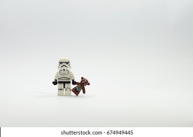 selangor, malaysia. june 4, 2017. Lego stormtrooper minifigure holding teddy bear isolated on white background. Lego minifigures are manufactured by The Lego Group.