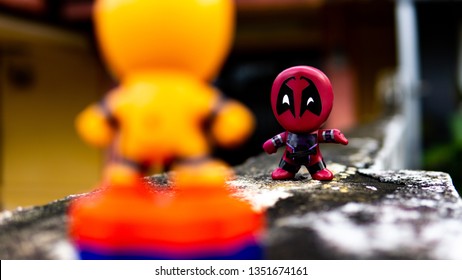 Selangor , Malaysia - March 28, 2019: Two McDonald's toy Deadpool and orange spiderman having a final fight on the road.