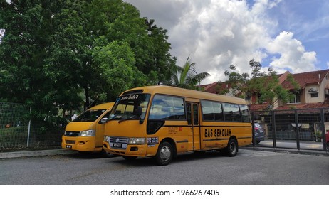 Selangor, Malaysia - May 2,2021: Horizontal shot of a line of parked yellow school buses under a blue sky. This photo contains noise and grain. 