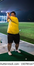 Selangor, Malaysia - September 17, 2019: A Portrait Of A Man Playing Golf At Puncak Alam Golf Driving Range During The Night. Leisure Activity Concept.