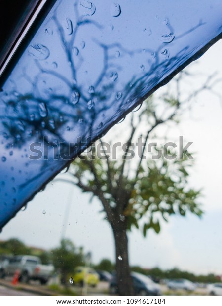 Selected focus drop of water on the glass outside\
the car after  raining