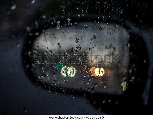 Selected focus drop of water on the\
glass outside the car in the raining day. Blur\
background.