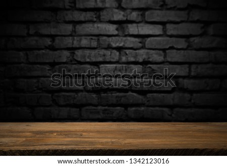 Selected focus empty brown wooden table and wall texture or old black brick wall blur background image. for your photomontage or product display