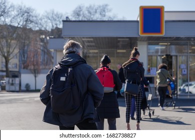 Selected focus, European people queue on street outside supermarket during quarantine for COVID-19 virus in Düsseldorf, Germany.